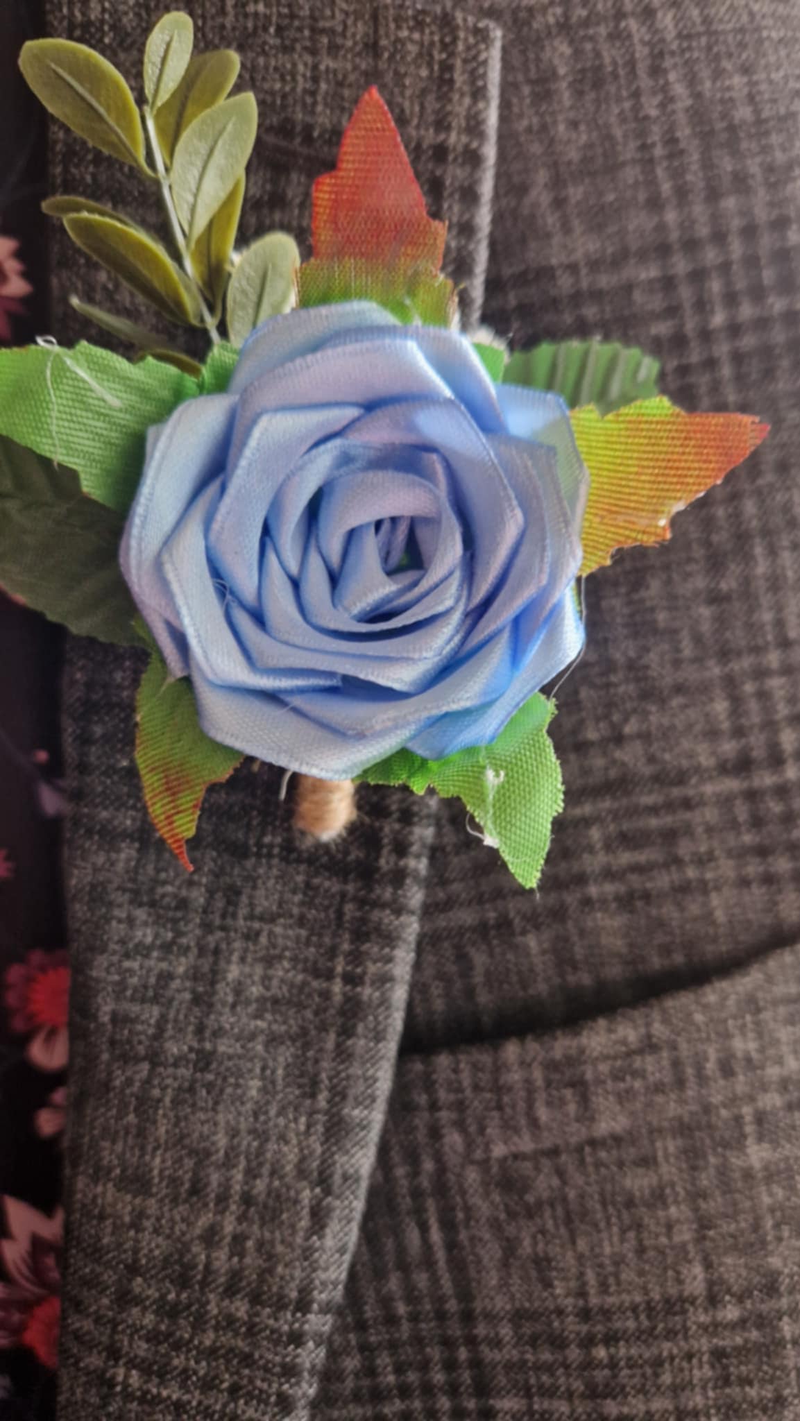 Handmade bluebird satin rose boutonniere pinned on gray checkered blazer lapel