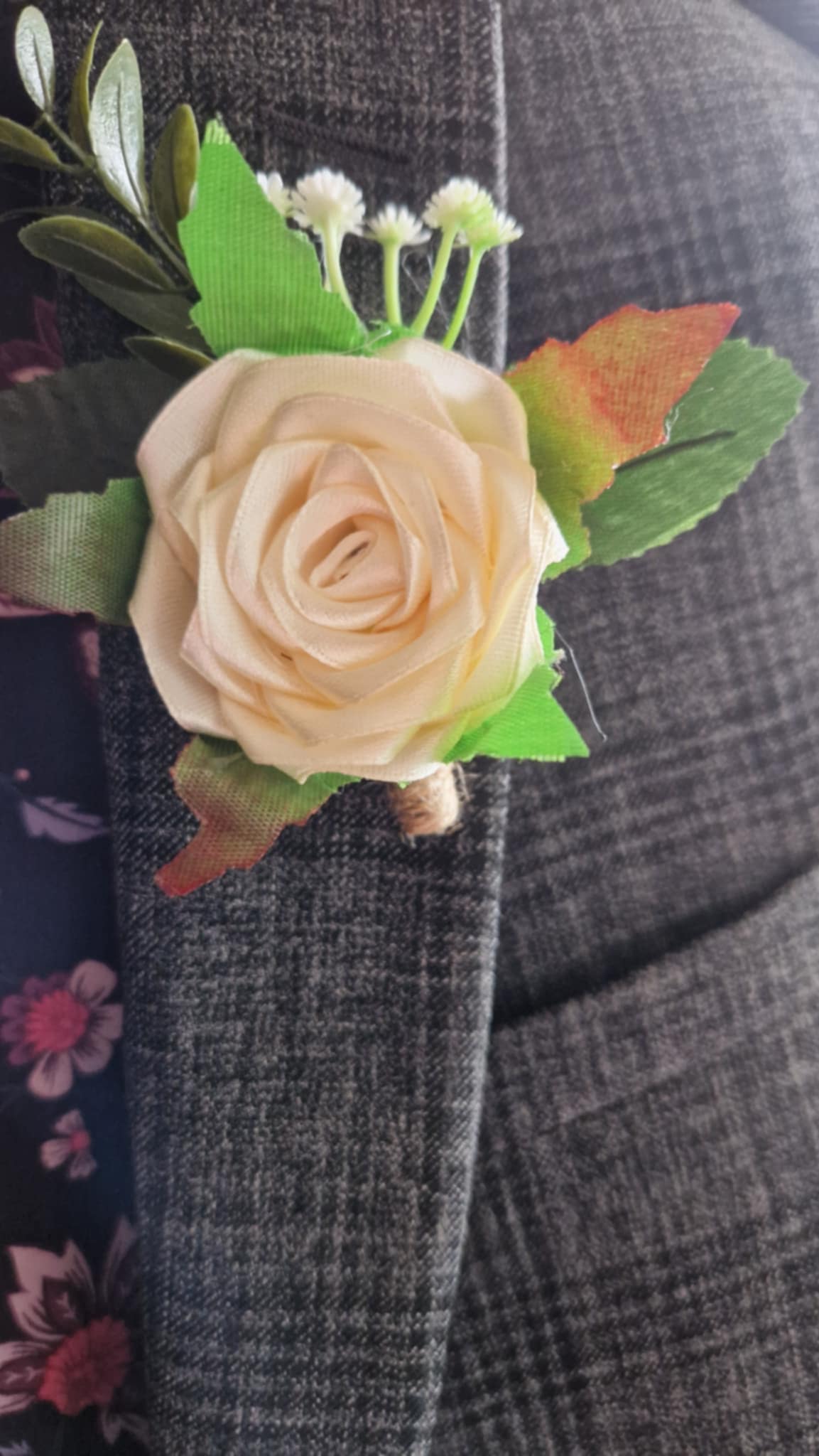 Handmade cream satin rose boutonniere pinned on gray suit jacket from The Satin Rose Shop