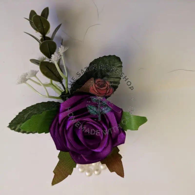 Handmade Purple Satin Rose Corsages with green leaves and small white flowers from The Satin Rose Shop